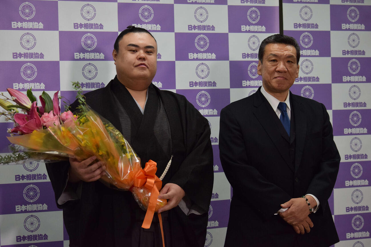 引退会見で花束を持ち写真に納まる英乃海（左）と木瀬親方（撮影・山田遼太郎）