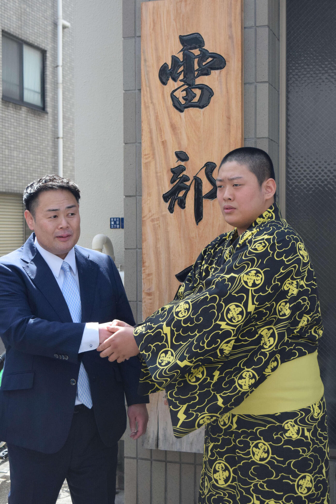 部屋の前で記念写真に納まる垣添玄空（右）と雷親方（元小結垣添）（撮影・山田遼太郎）