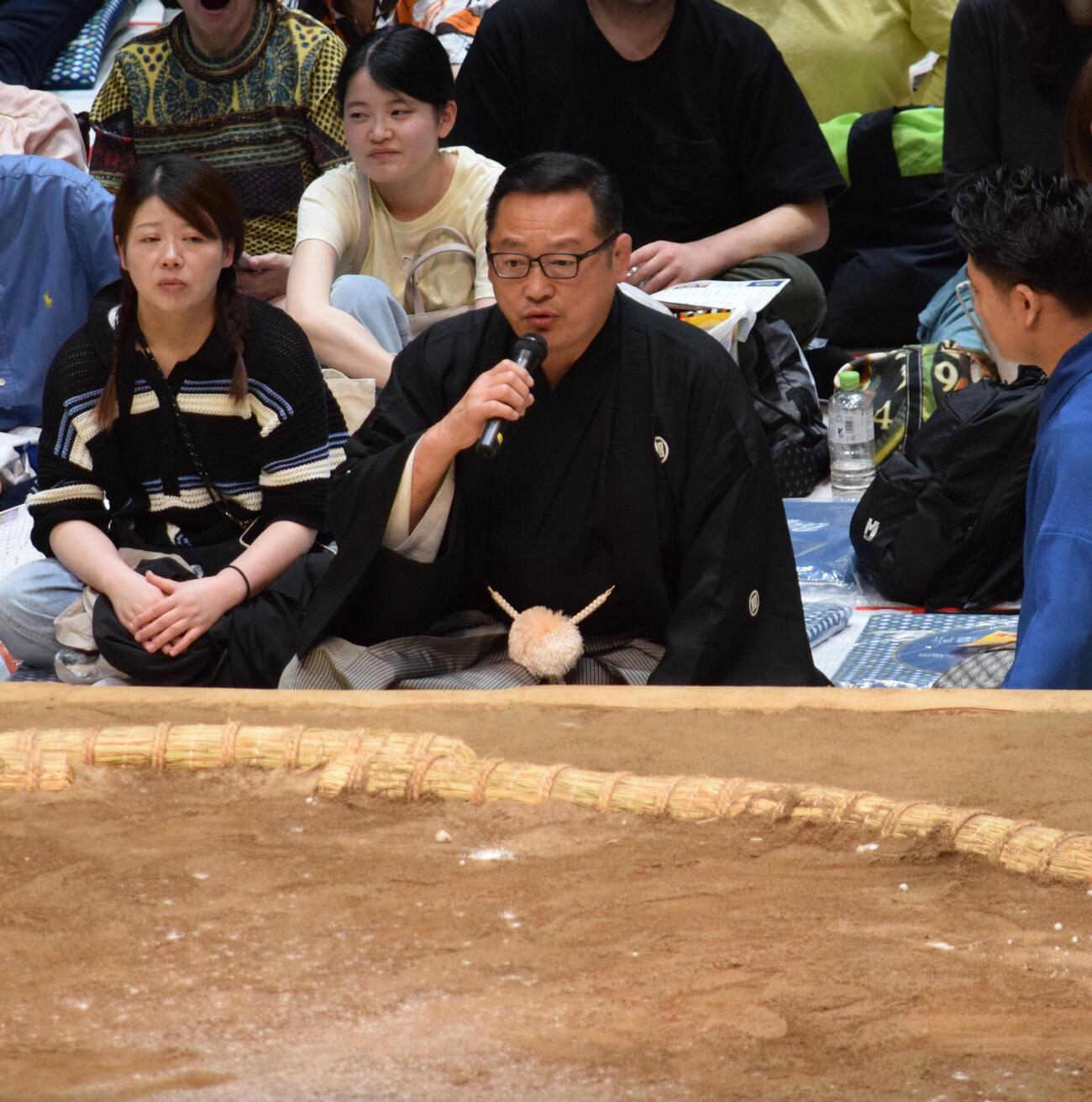 場内アナウンスで説明する尾上親方（撮影・山田遼太郎）