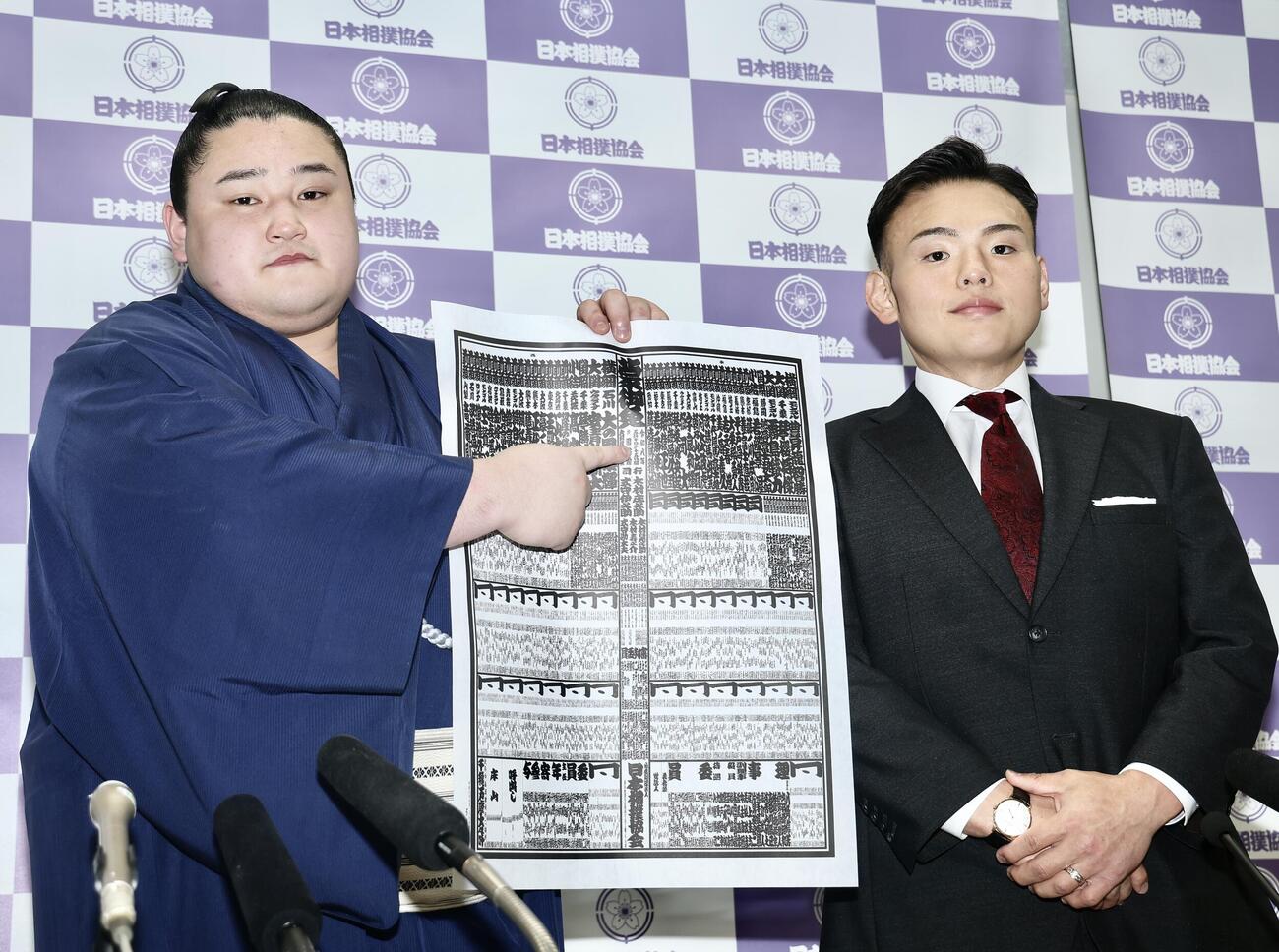 番付発表会見　番付表を手に写真に納まる若ノ勝（左）と湊川親方　