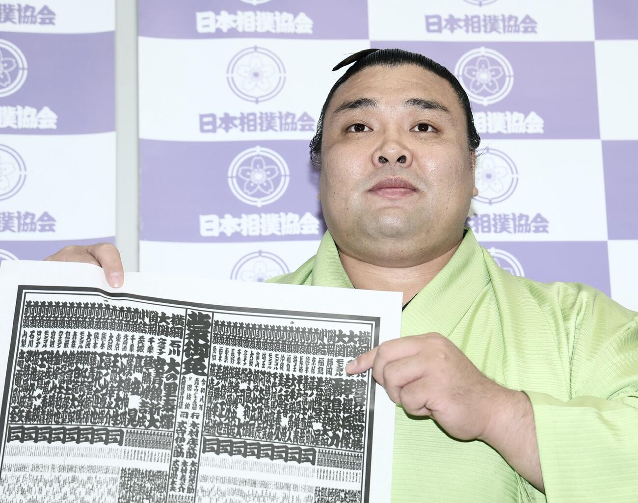 番付発表会見　番付表を手に写真に納まる霧島＝2026年4月27日　