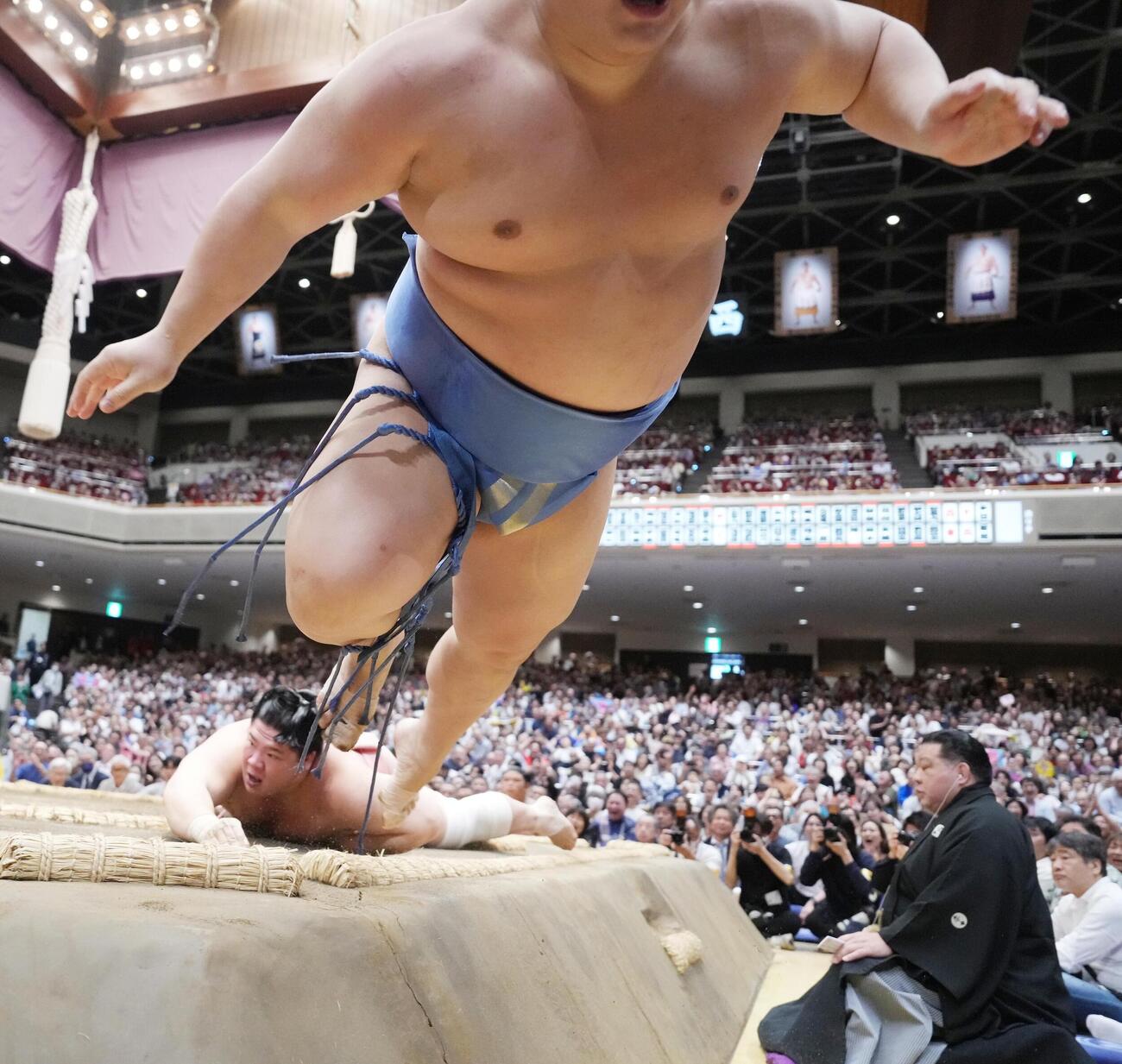 大相撲夏場所8日目　宇良（後方）に押し出され土俵から飛び出す翔猿（撮影・小沢裕）