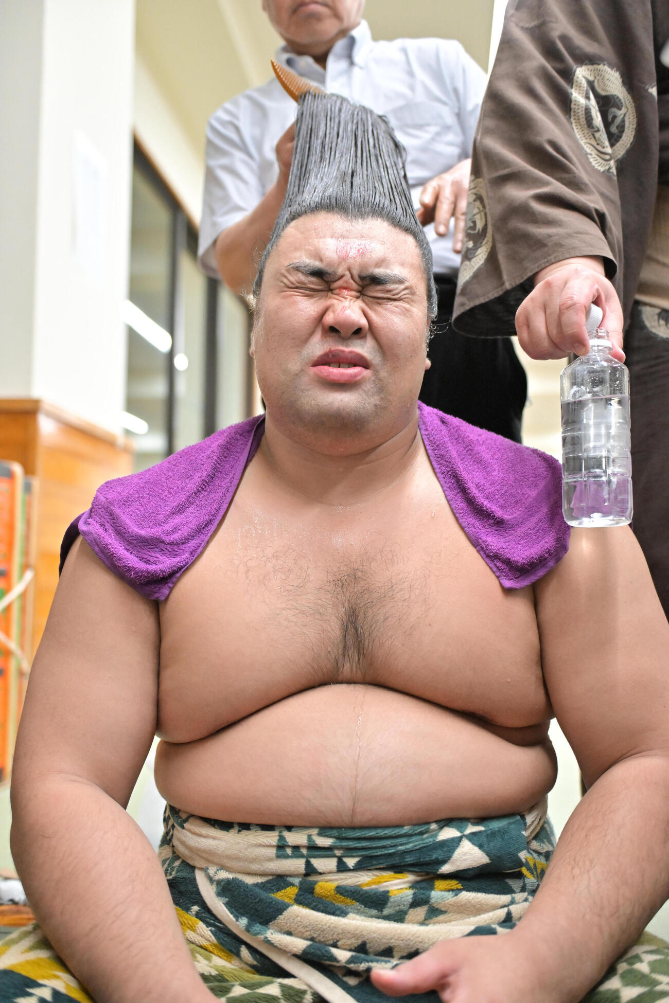 支度部屋でまげを結う霧島