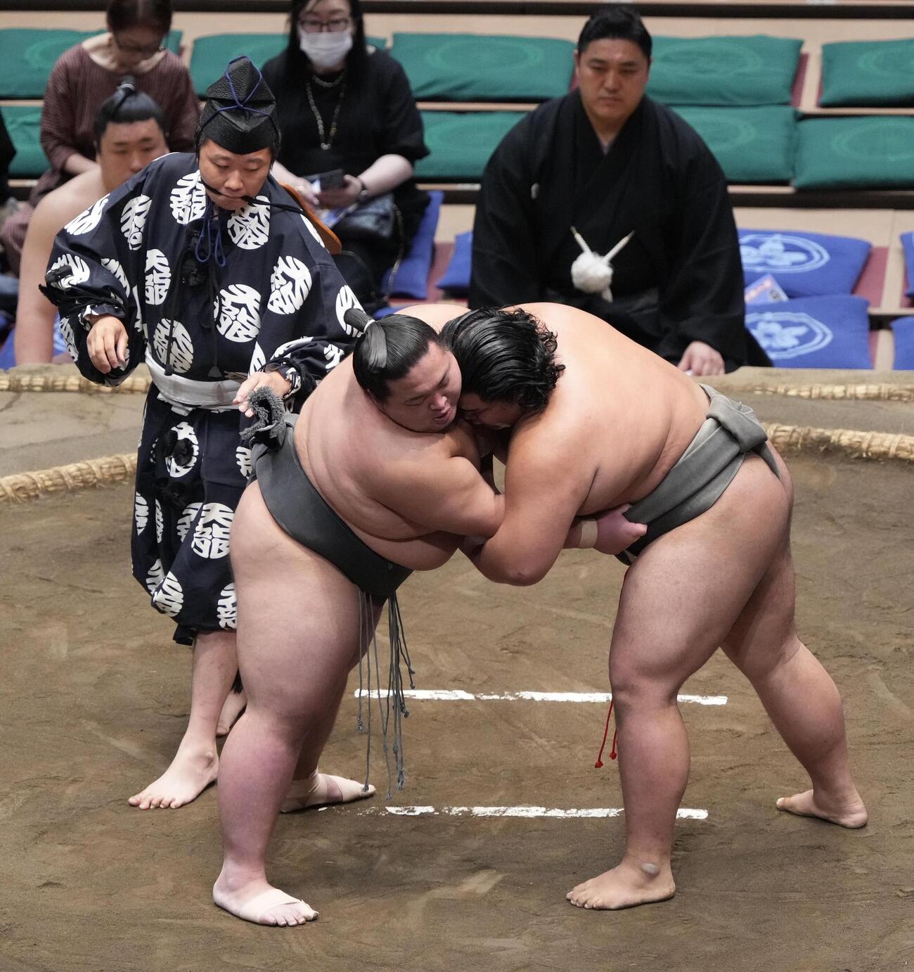 大相撲夏場所11日目　大斧（左手前）と竜鳳の一番で「まわし待った」をかけた行司の木村悟志は最後に大斧のまわしをチェックする（撮影・小沢裕）　＝2026年5月20日