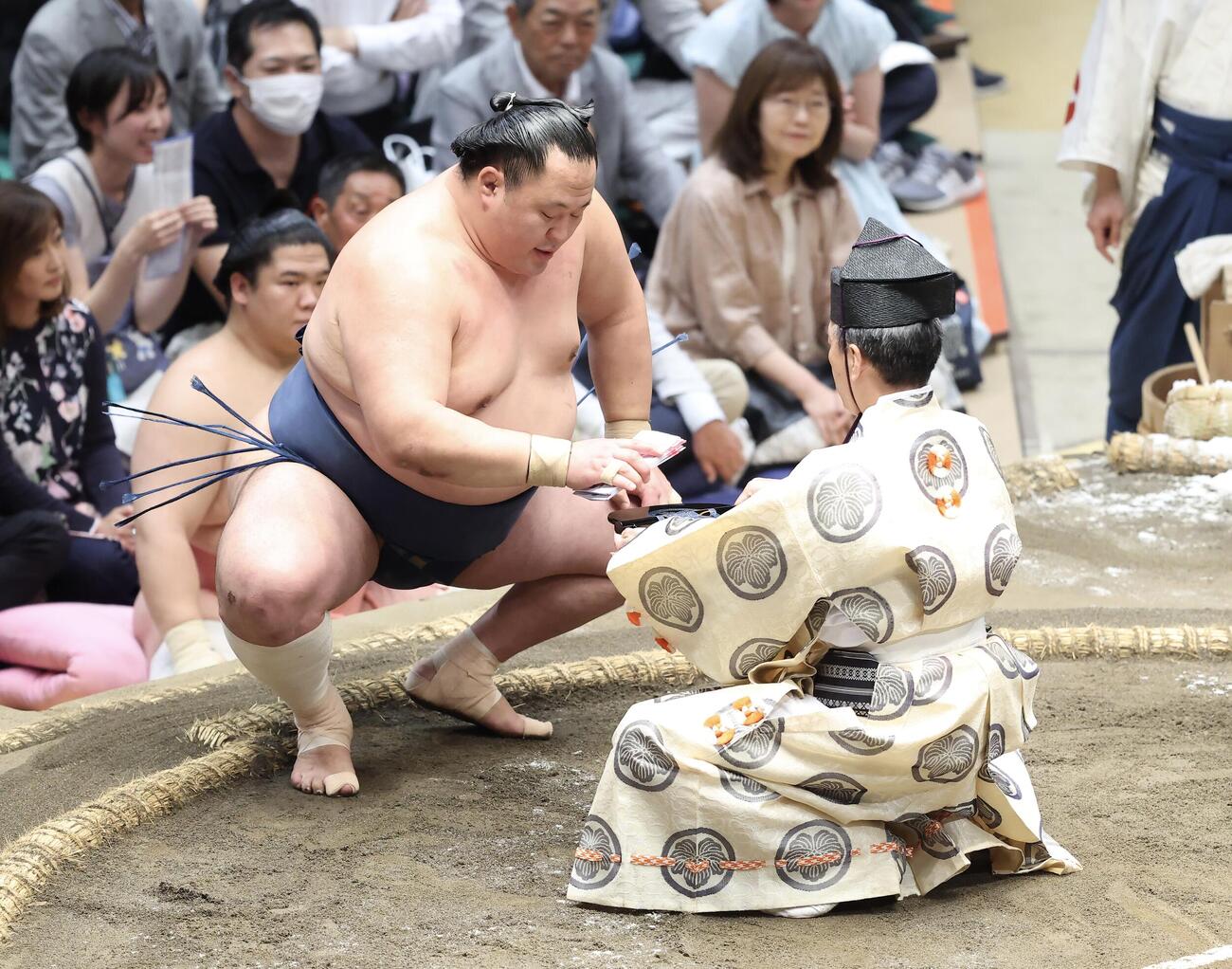 大相撲夏場所　11日目　金峰山を突き落としで破り、懸賞金を受け取る玉鷲（撮影・河田真司）