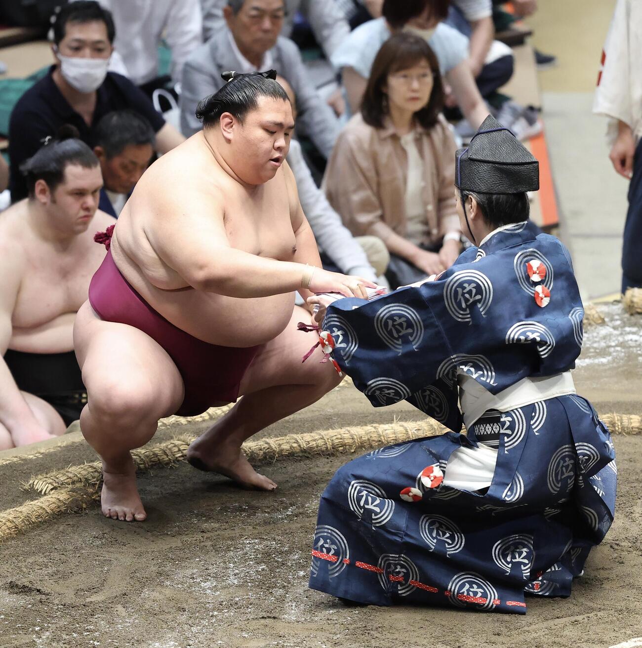 大相撲夏場所　11日目　羽出山を押し出しで破り、懸賞金の束を手にする御嶽海（撮影・河田真司）
