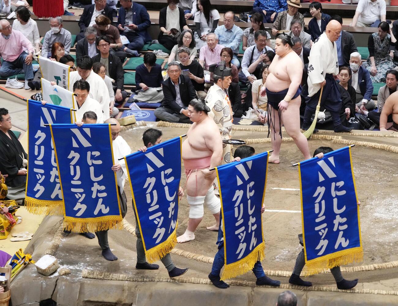 大相撲夏場所11日目　宇良と若ノ勝の一番で土俵をまわる「にしたんクリニック」の懸賞旗（撮影・小沢裕）