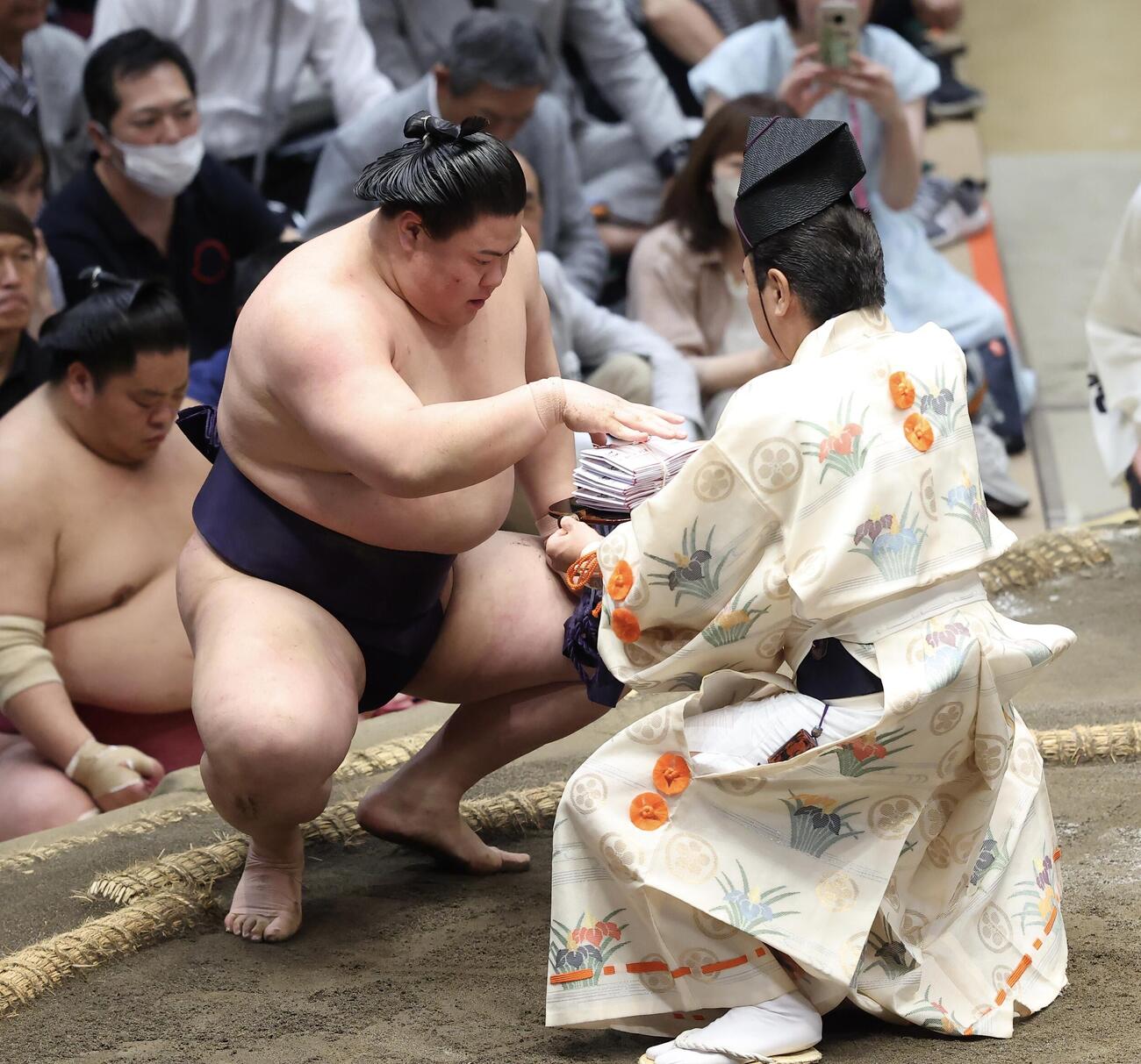 大相撲夏場所　11日目　平戸海を下手投げで破り、懸賞金を受け取る義ノ富士（撮影・河田真司）