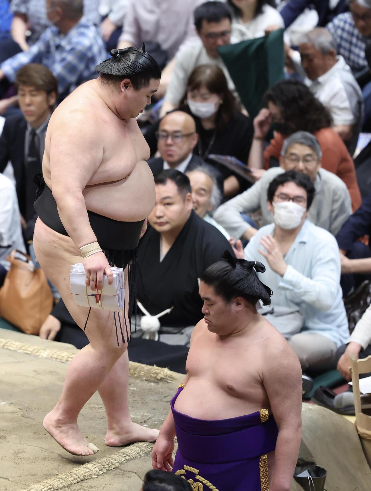 大相撲夏場所　11日目　琴桜を送り出しで破り、懸賞金の束を手に土俵から引き揚げる正代（撮影・河田真司）