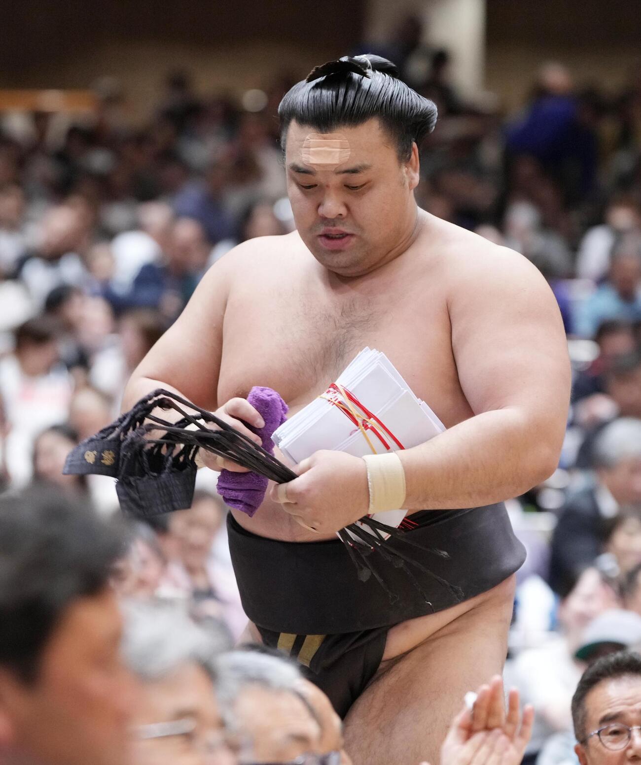 大相撲夏場所12日目　懸賞の束を手に引き揚げる霧島（撮影・小沢裕）　＝2026年5月21日