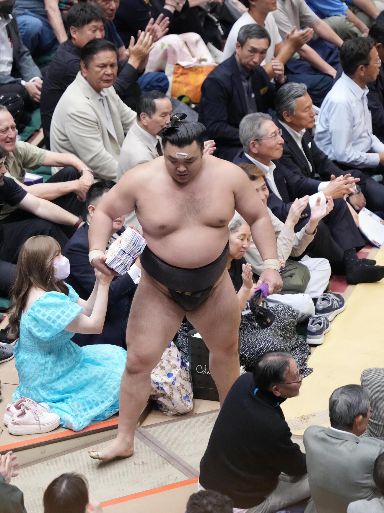 大相撲夏場所13日目　霧島を死守した霧島は懸賞の束を手に花道を引き揚げる（撮影・小沢裕）　＝2026年5月22日
