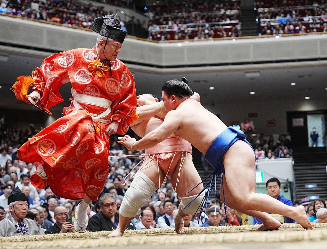 大相撲夏場所14日目　宇良は土俵際で藤ノ川（右）をかわし突き落としで破る。2人の俊敏な動きに合わせるように取組を裁いた行司の木村晃之助（左）も逃げ回った（撮影・小沢裕）