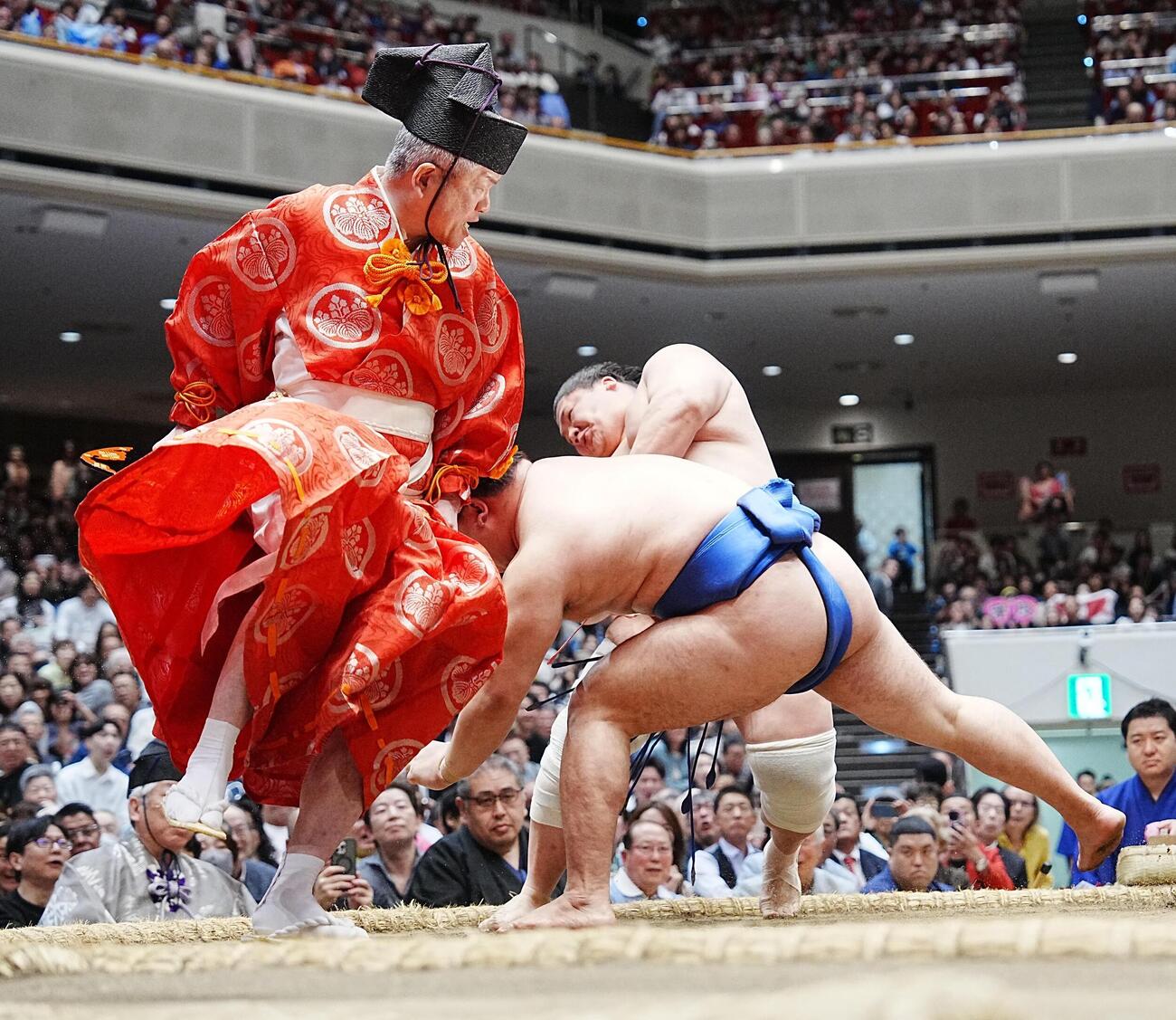 大相撲夏場所14日目　宇良（後方）は土俵際で藤ノ川をかわし突き落としで破る。2人の俊敏な動きに合わせるように取組を裁いた行司の木村晃之助（左）も逃げ回った（撮影・小沢裕）