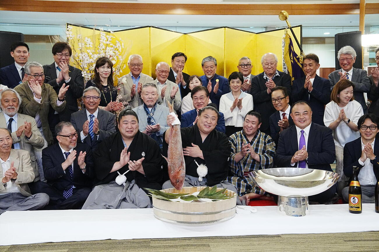 大相撲夏場所千秋楽　優勝祝賀会会場で後援会関係者の祝福を受けながら鯛を持ち上げる若隆景（中央）。前列左2人目から次兄の若元春、1人おいて長兄の若隆元、荒汐親方（撮影・小沢裕）