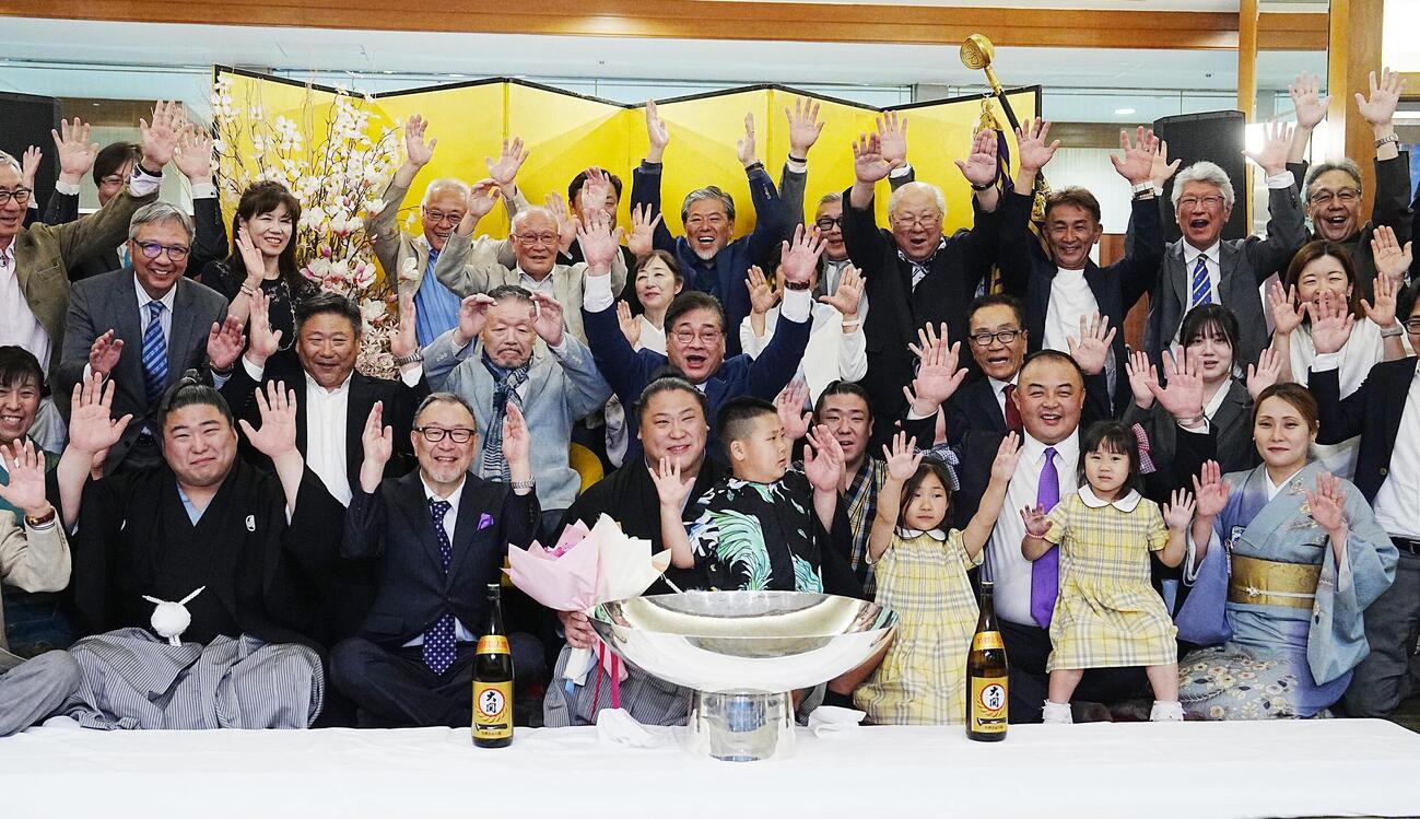 家族や次男若元春（前列左端）、長男若隆元、荒汐親方らの祝福を受け記念撮影に納まる若隆景（中央）。2列目左から3人目は先代荒汐親方（撮影・小沢裕）
