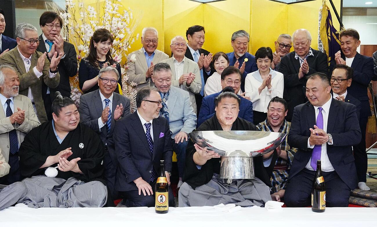 大相撲夏場所千秋楽　優勝祝賀会会場で後援会関係者の祝福を受けながらお祝いのお酒が注がれた銀杯を持ち上げる若隆景（中央）。前列左から次兄の若元春、2人おいて長兄の若隆元、荒汐親方（撮影・小沢裕）