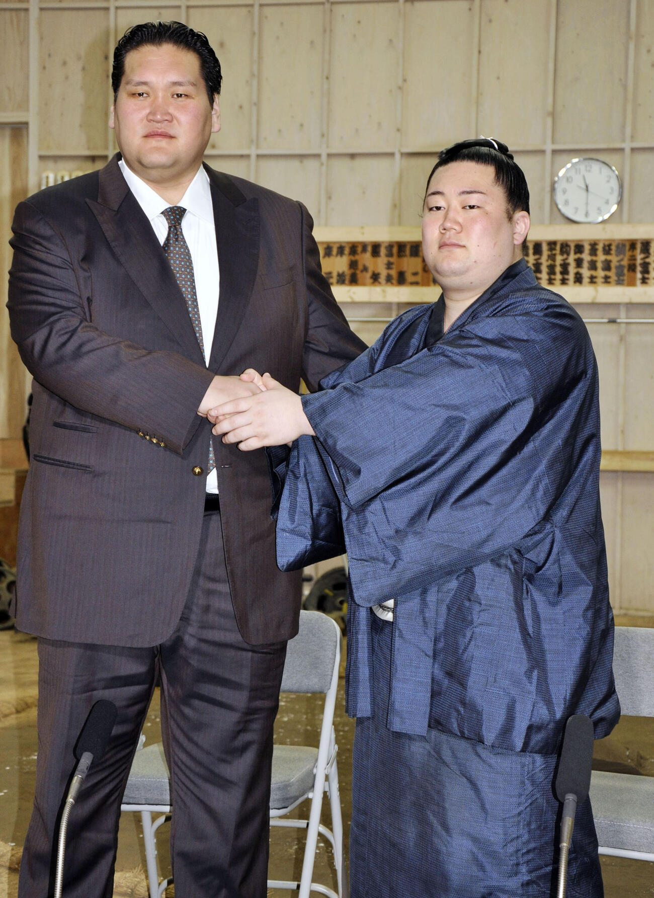 師匠の伊勢ケ浜親方（左）と握手する新十両の嵐富士（共同）