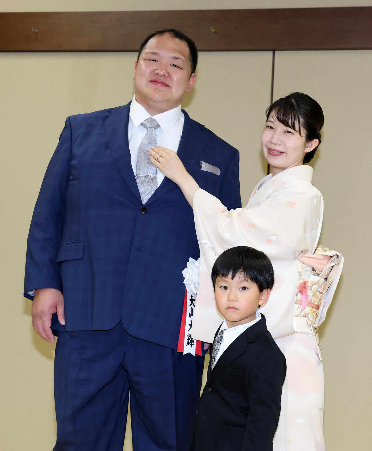 真美夫人にネクタイを直してもらう北勝富士改め大山親方（撮影・鈴木正人）
