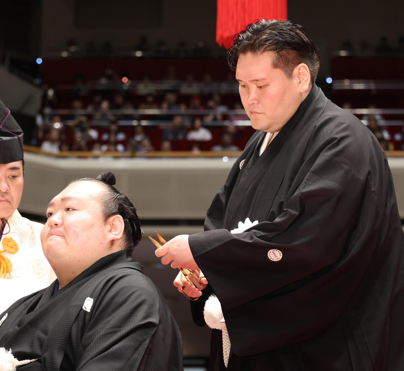 伊勢ヶ浜親方（右）に挟みを入れてもらう宝富士（撮影・中島郁夫）