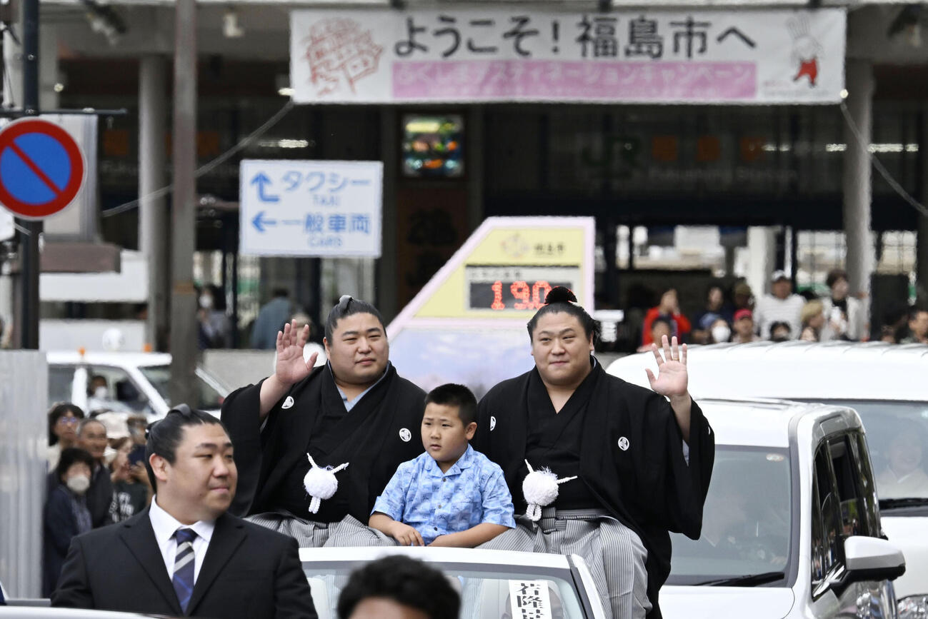 大相撲夏場所優勝の祝賀パレードで手を振る若隆景。左は兄の若元春（共同）