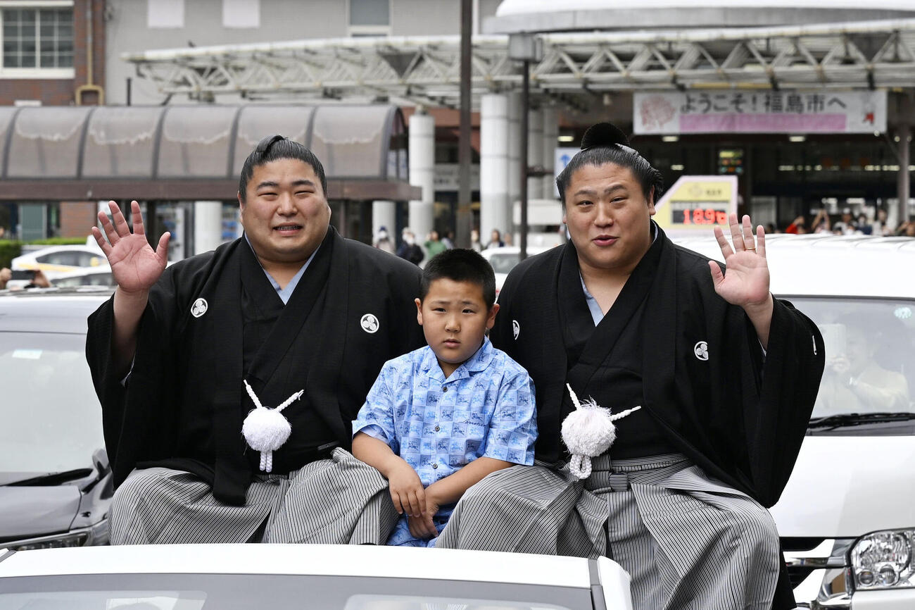 大相撲夏場所優勝の祝賀パレードで手を振る若隆景関。左は兄の若元春関（共同）