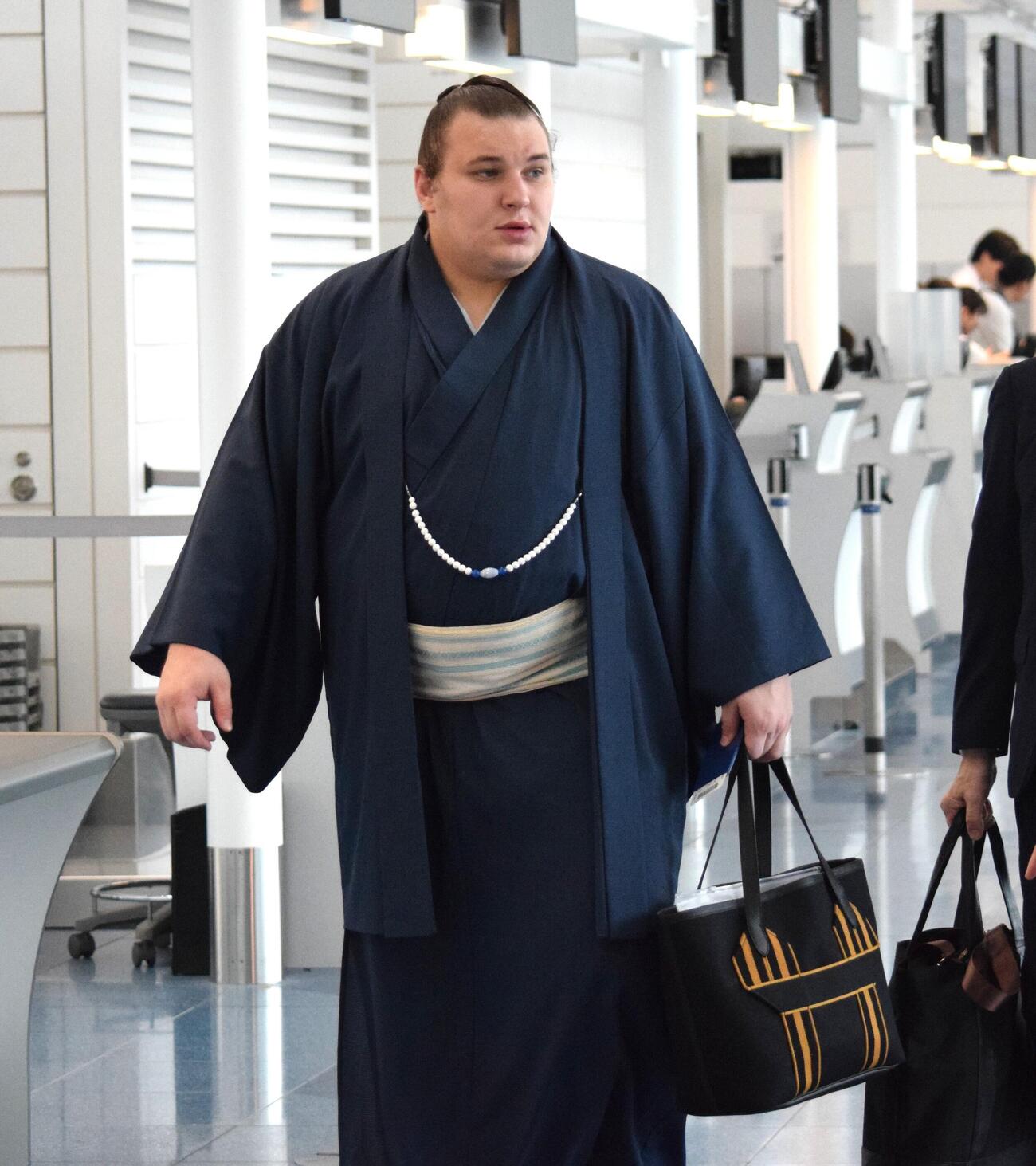 エルメスのトートバッグを持ち搭乗口へ向かう安青錦（撮影・山田遼太郎）