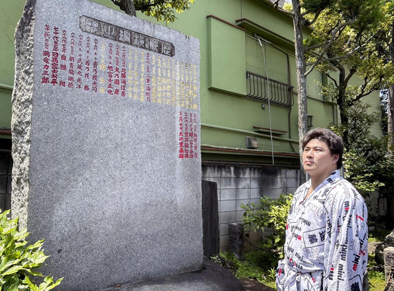 歴代横綱のしこ名が刻まれた石碑の前に立つ大森（共同）