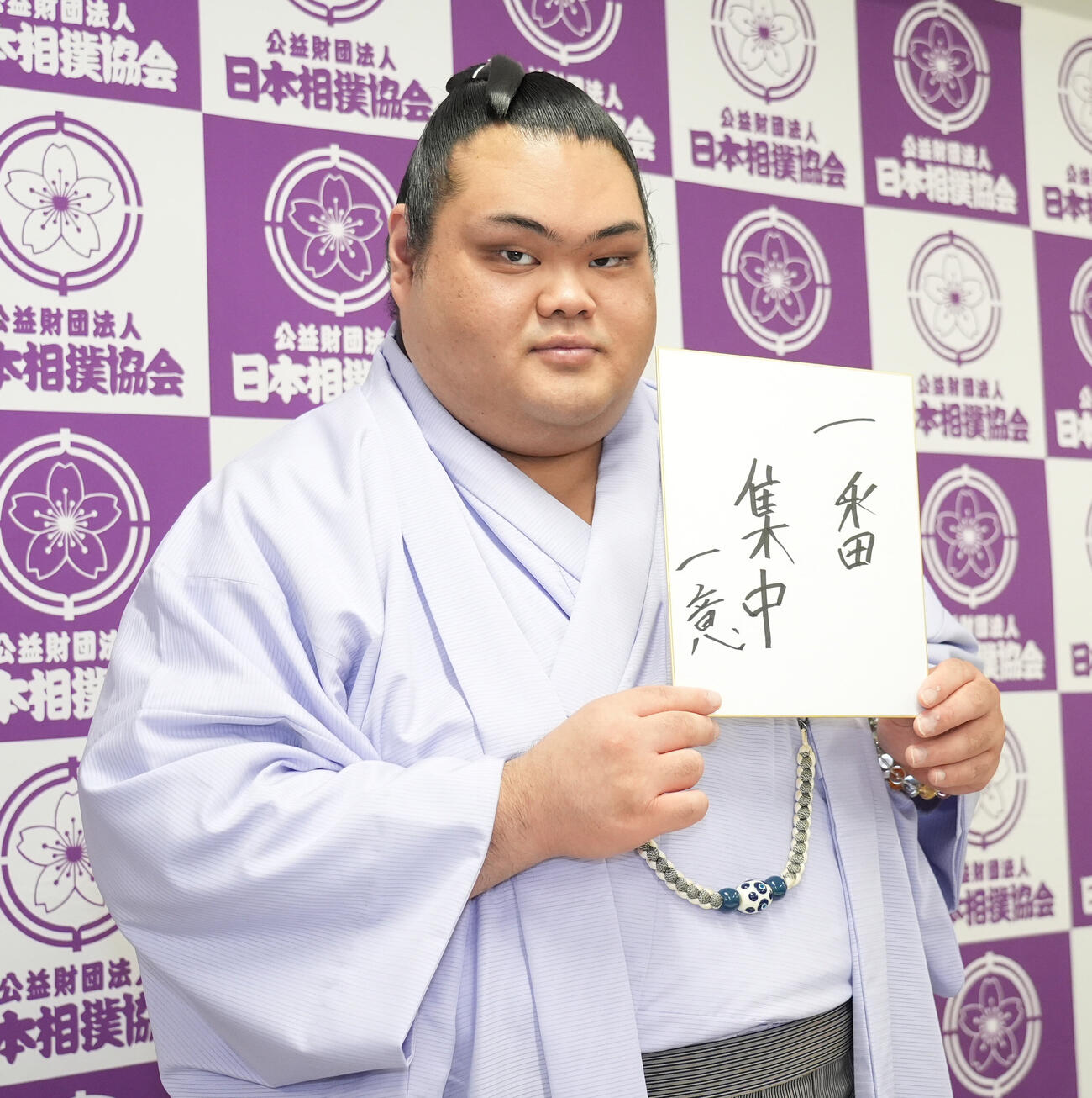 会見後、今場所の抱負を記した色紙を手にする一意（撮影・森本幸一）