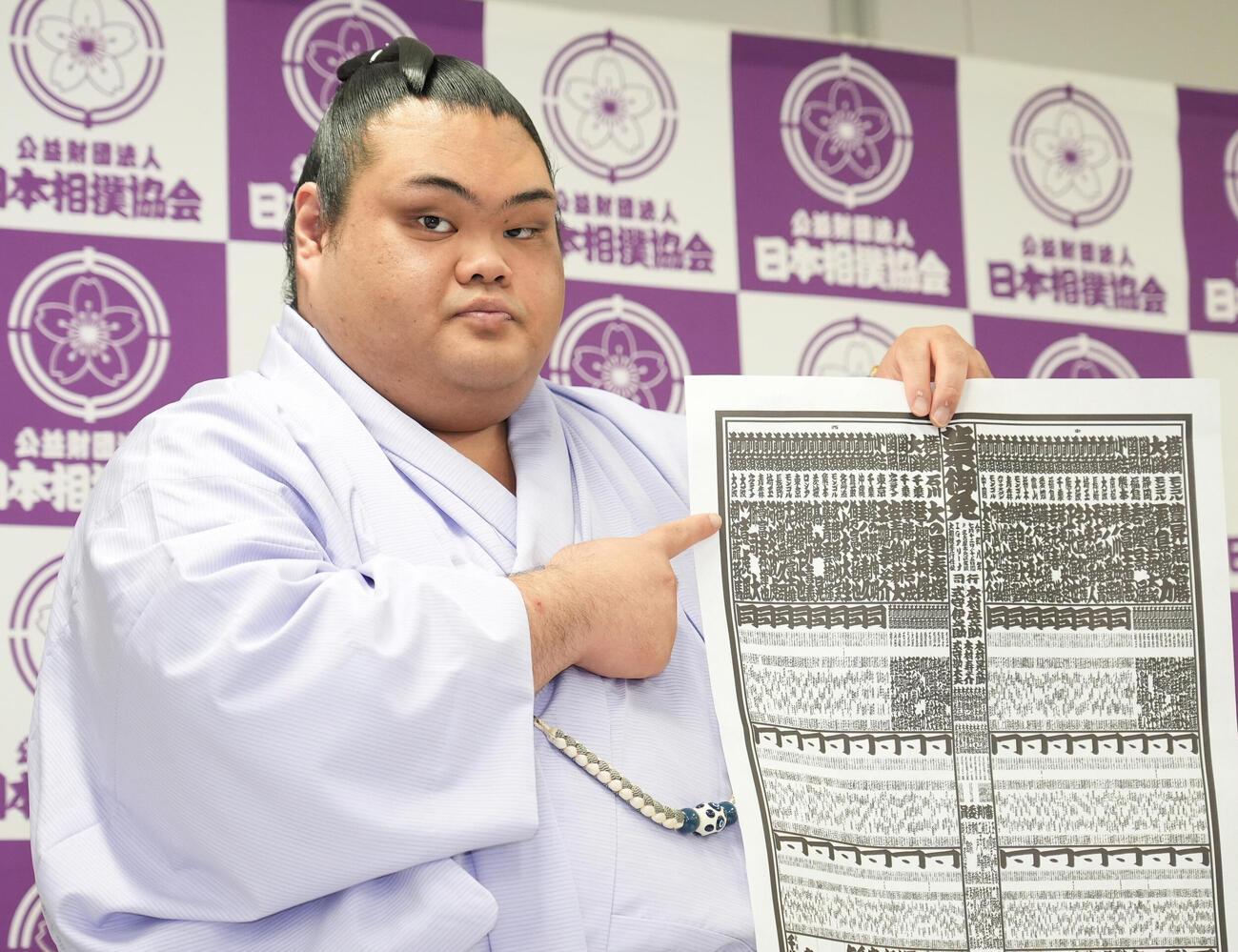 番付表を手にしこ名を指さす一意（撮影・森本幸一）