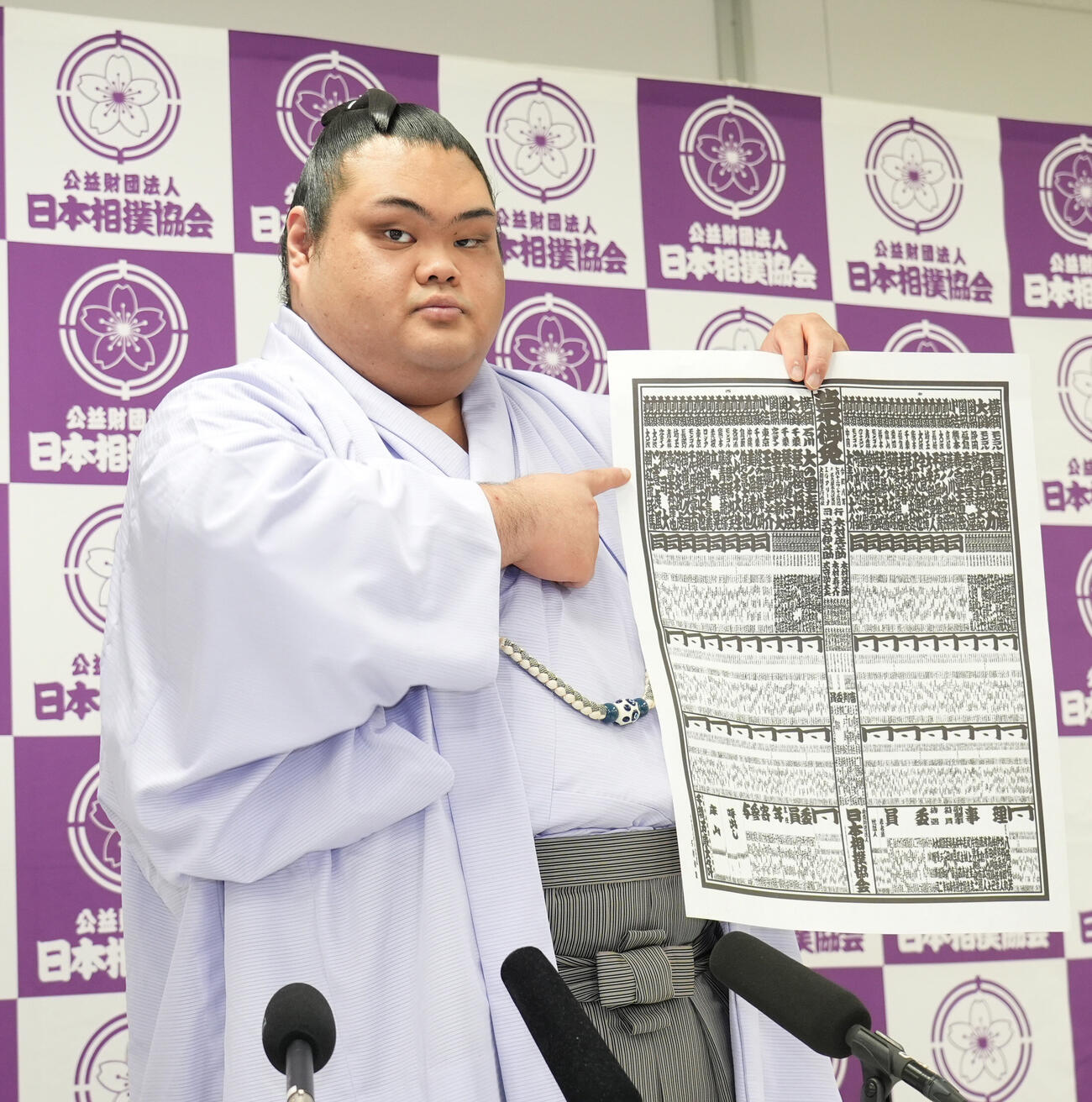 番付表を手にしこ名を指さす一意（撮影・森本幸一）