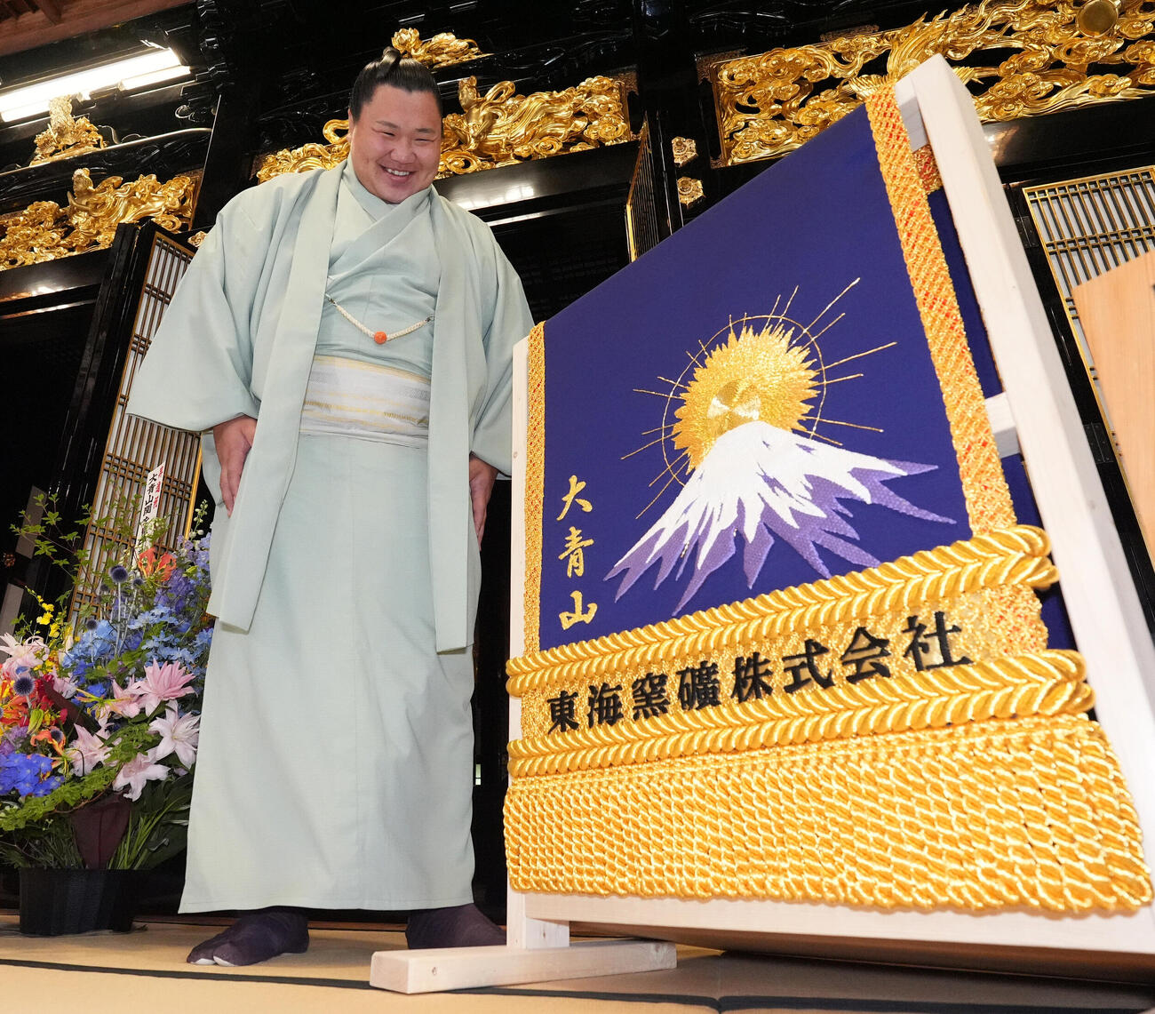 会見後、贈呈された化粧まわしに笑顔を見せる大青山（撮影・森本幸一）