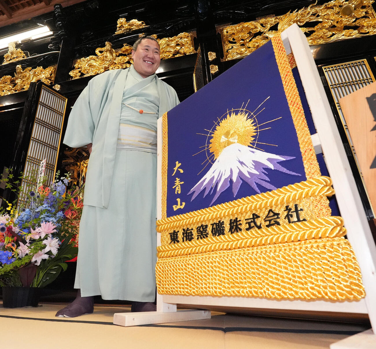 会見後、贈呈された化粧まわしに笑顔を見せる大青山（撮影・森本幸一）