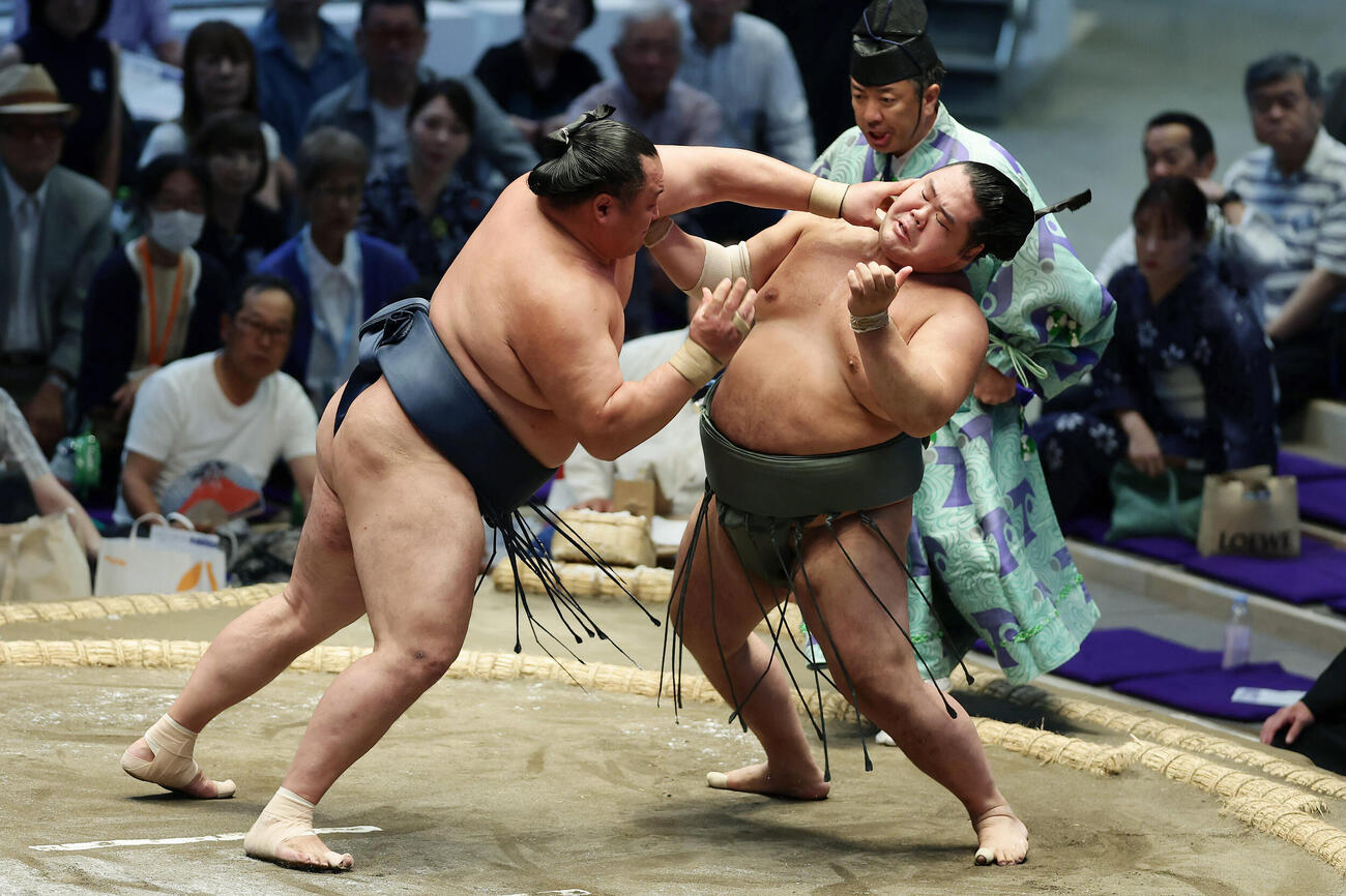 明生（右）を押し出しで破る玉鷲（撮影・前田充）