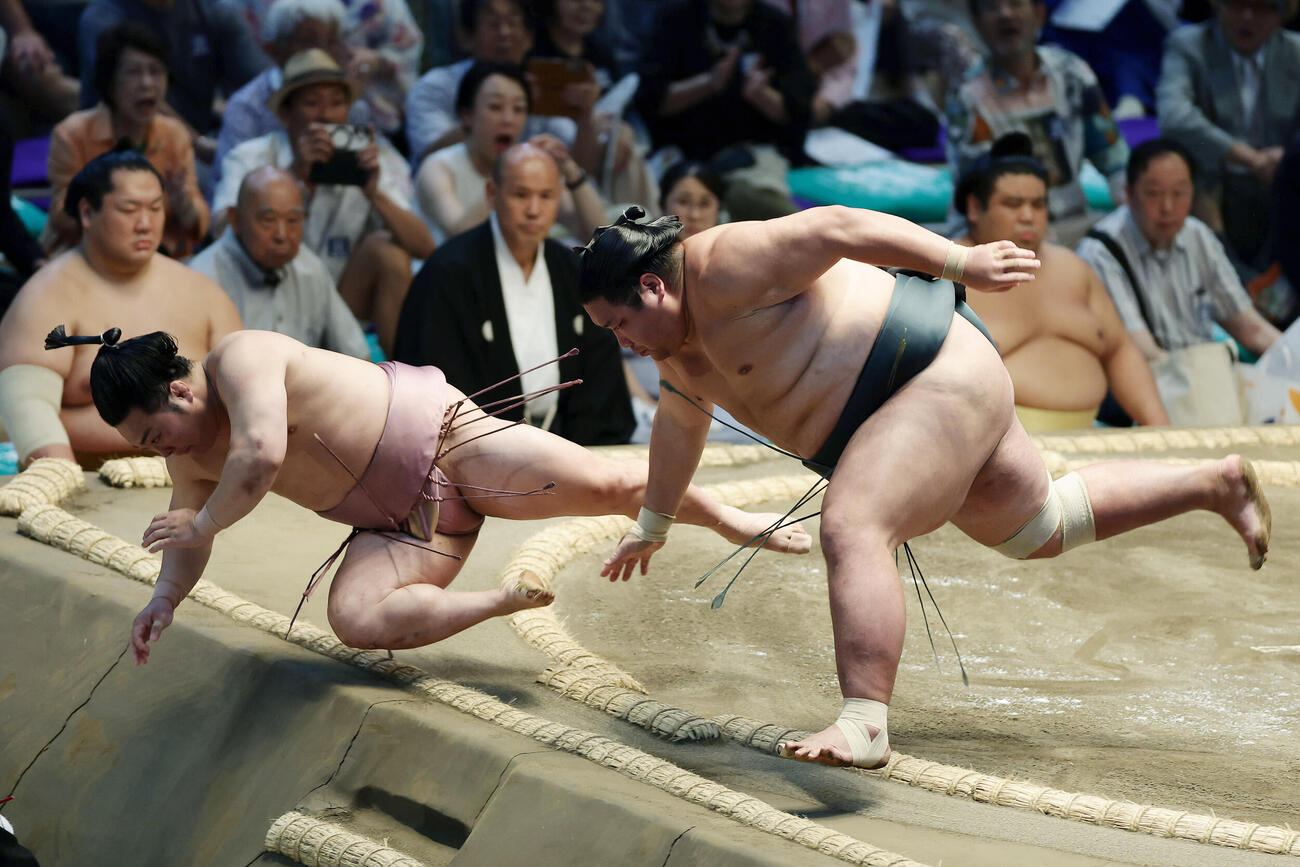 炎鵬（左）を押し倒しで破る錦木（撮影・前田充）