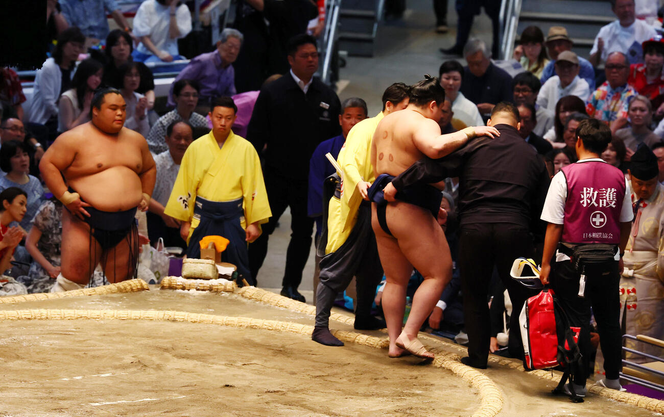 藤凌駕に敗れ負傷した若ノ勝は関係者の手を借りて土俵上から引き揚げる（撮影・加藤哉）