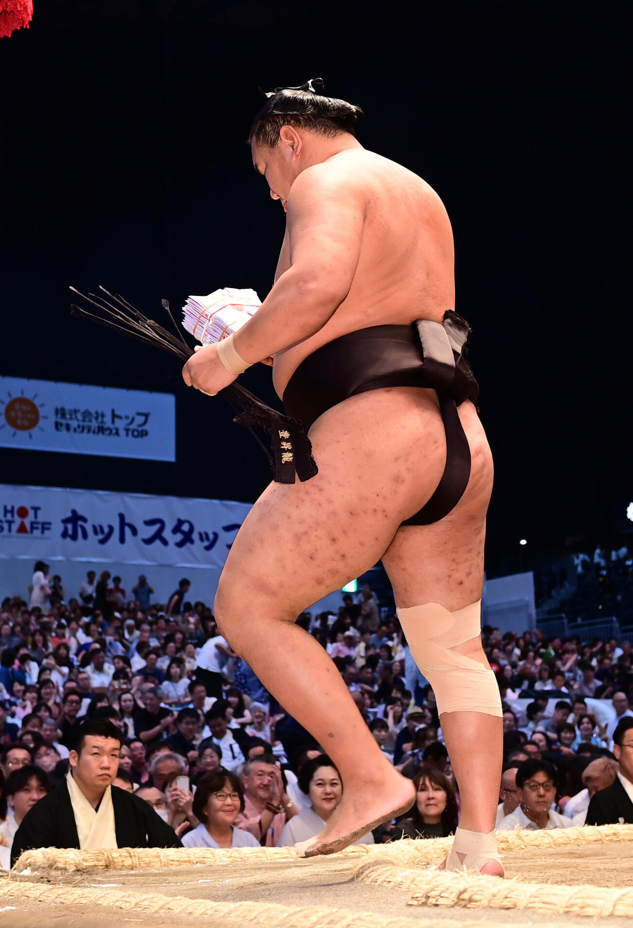 豊昇龍は平戸海をすくい投げで破り懸賞を手に土俵を降りる（撮影・森本幸一）
