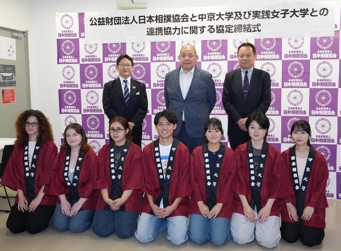 日本相撲協会連携協力協定締結会見し署名を行い学生たちと記念撮影に納まる後列・左から中京大学の梅村清英学長、日本相撲協会の八角信芳理事長、実践女子大学の難波雅紀学長（撮影・森本幸一）