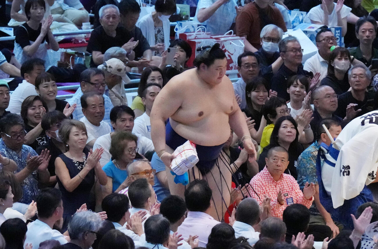 大の里は懸賞を手に花道を引き揚げる（撮影・森本幸一）