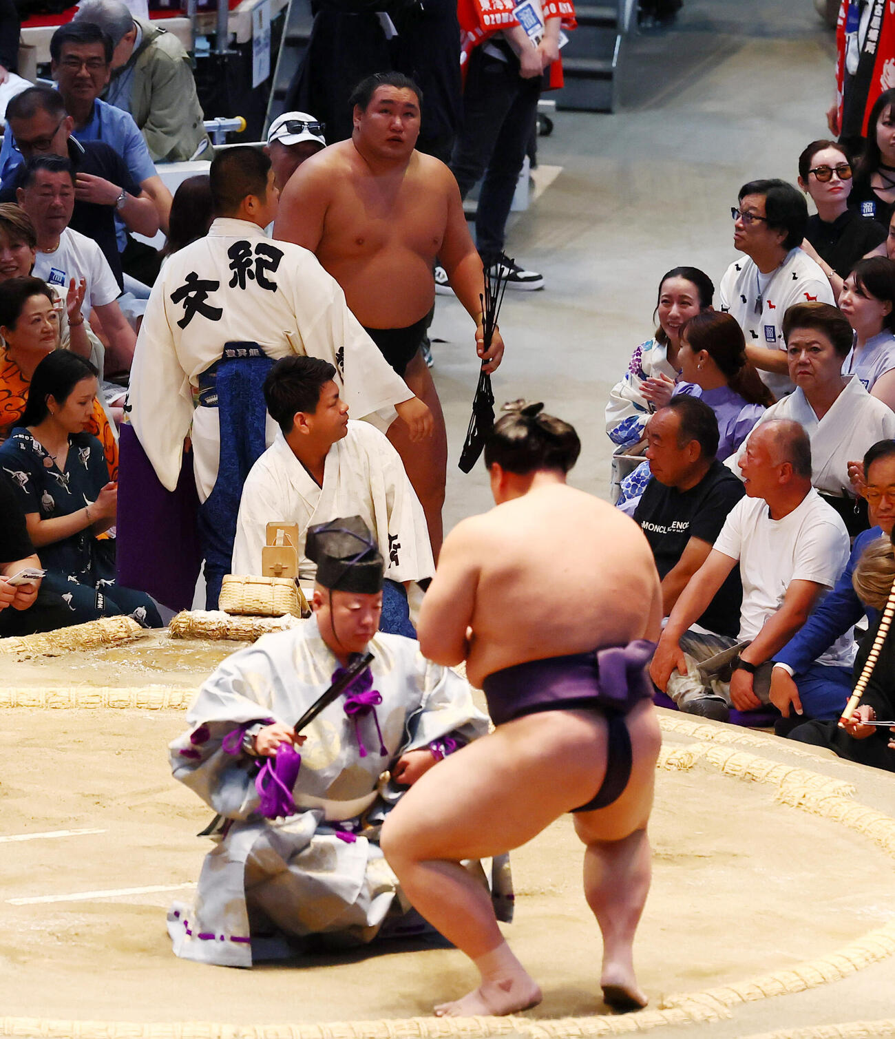 敗れた豊昇龍は支度部屋へ引き揚げる。土俵上は勝ち名乗りを受ける義ノ富士（撮影・加藤哉）
