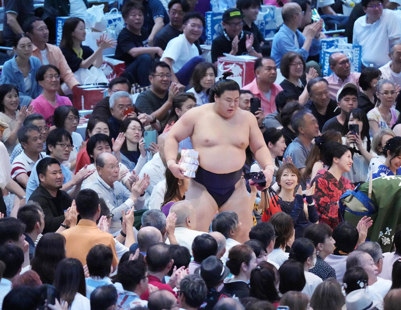 懸賞を手に花道を引き揚げる義ノ富士（撮影・森本幸一）