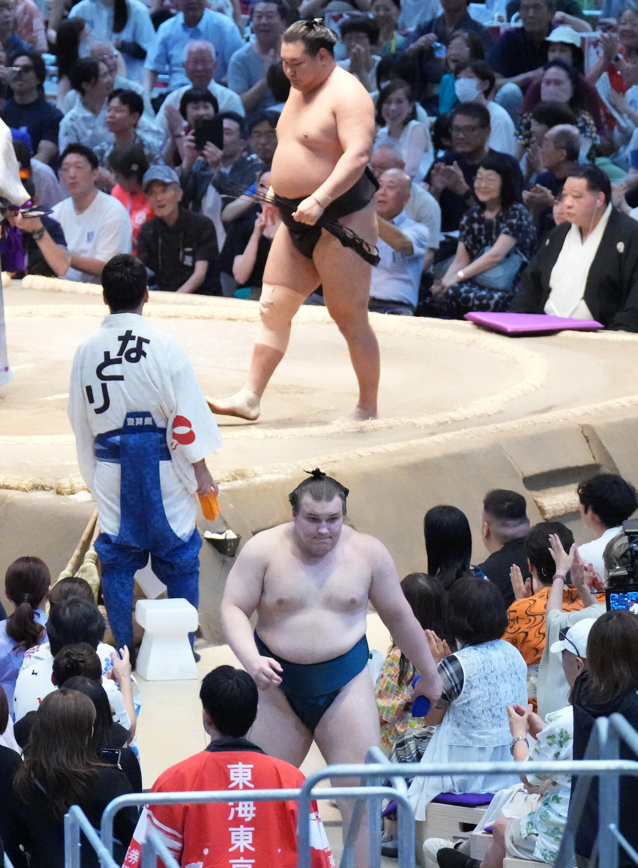花道を引き揚げる安青錦（手前）土俵上は義ノ富士に敗れた豊昇龍（撮影・森本幸一）