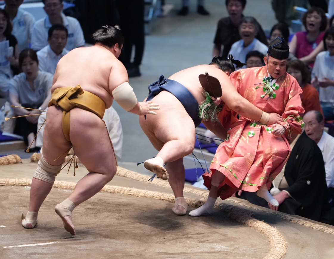 行き場を失った玉鷲は取組を裁いていた行司の木村勘九郎（右）を巻き込みながら土俵下に転げ落ちる（撮影・小沢裕）