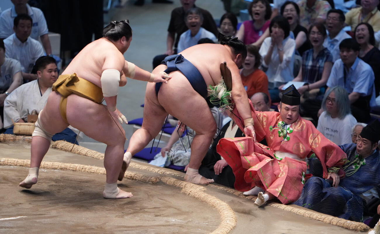 行き場を失った玉鷲は取組を裁いていた行司の木村勘九郎（右）を巻き込みながら土俵下に転げ落ちる（撮影・小沢裕）