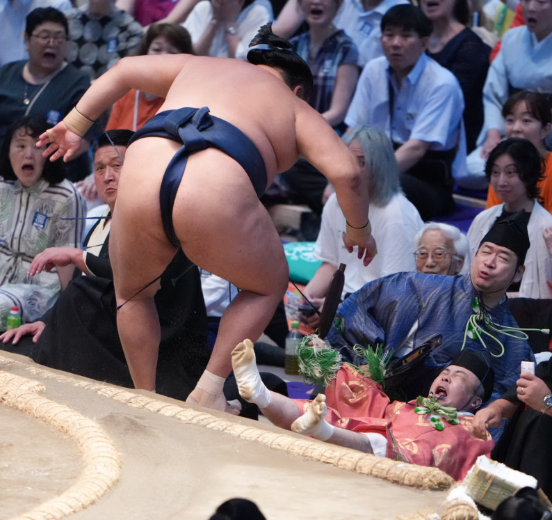 行き場を失った玉鷲は取組を裁いていた行司の木村勘九郎（右）を巻き込みながら土俵下に転げ落ちる（撮影・小沢裕）