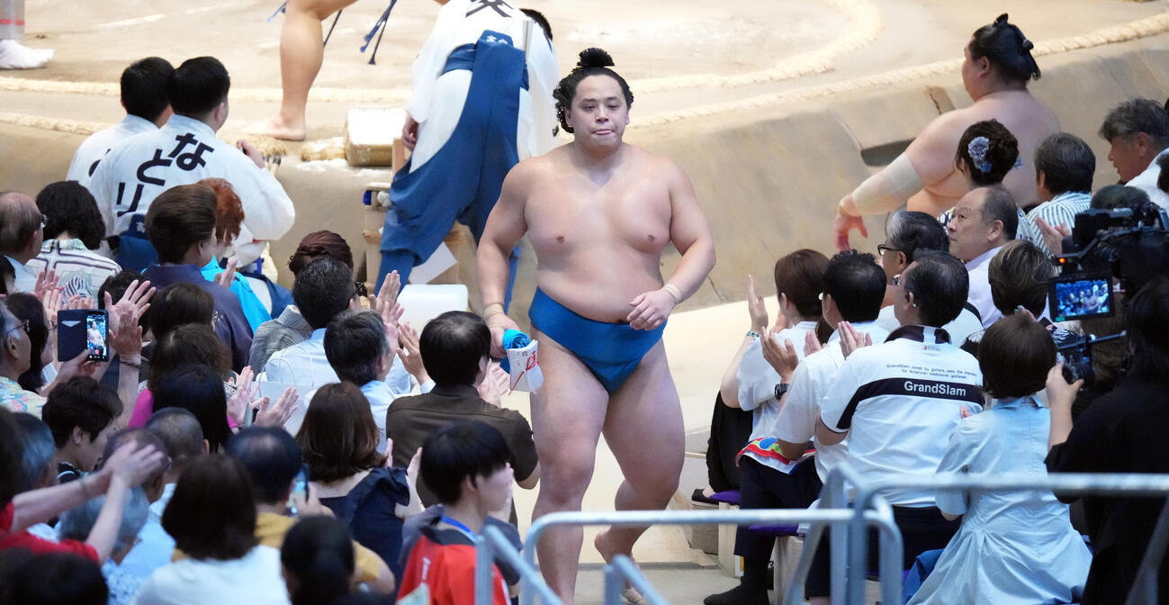 琴栄峰（中央）は阿炎を破り観客の拍手の中花道を引き揚げる（撮影・森本幸一）