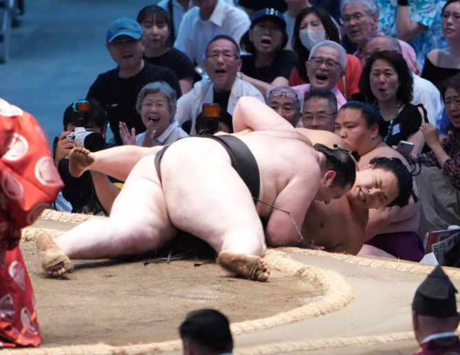 獅司（手前）は琴栄峰を寄り倒しで破る（撮影・小沢裕）