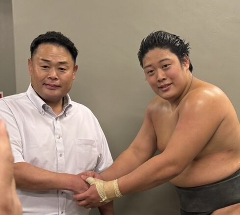 序ノ口優勝を果たした垣添（右）は師匠の雷親方（元小結垣添）と握手し、優勝を報告した