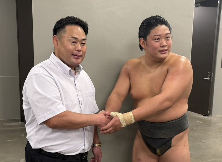 序ノ口優勝を果たした垣添（右）は師匠の雷親方（元小結垣添）と握手し、優勝を報告した