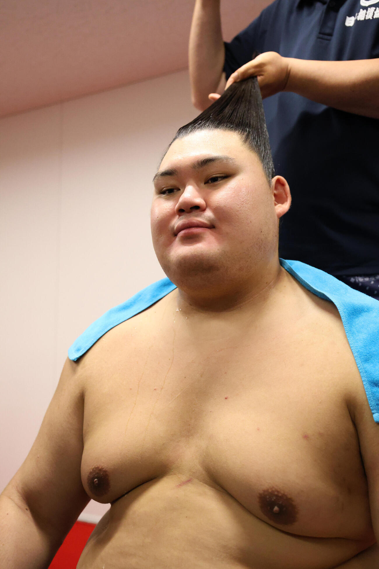 髪を結いながら記者に対応する大の里（代表撮影）