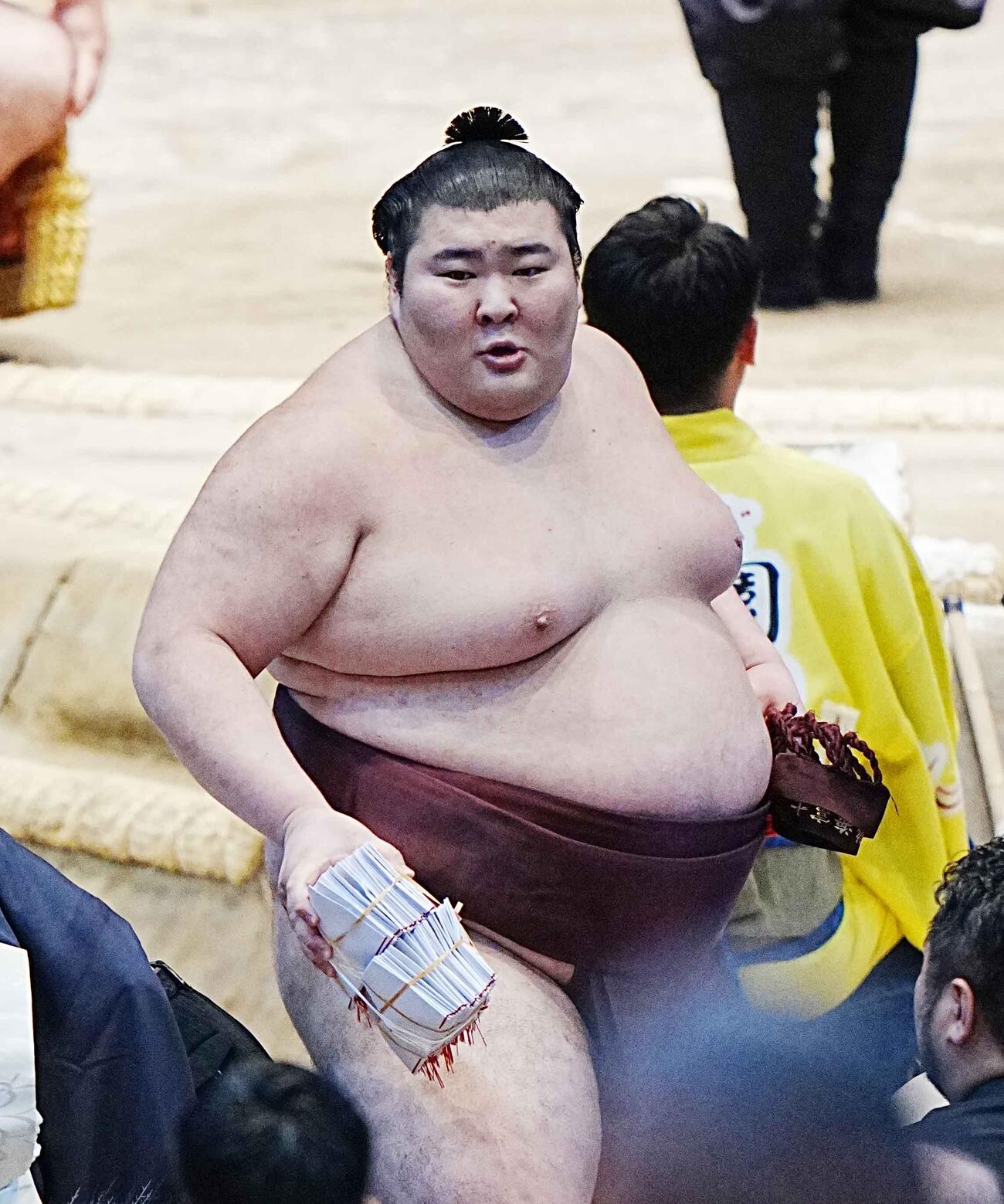 懸賞の束を手に笑顔で花道を引き揚げる熱海富士（撮影・小沢裕）